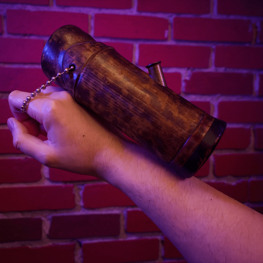 Handcrafted Bamboo Bong – Eco - Friendly Water Pipe with Natural AromaHand holding a bamboo bong against a brick wall with a red hue