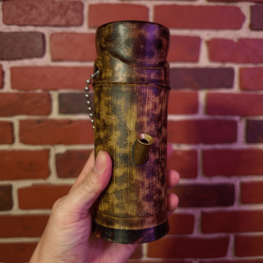 Handcrafted Bamboo Bong – Eco - Friendly Water Pipe with Natural AromaHand holding a bamboo bong against a brick wall