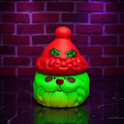 Herb Grinder – Holiday Edition, Green herb grinder with a red hat against a brick wall background