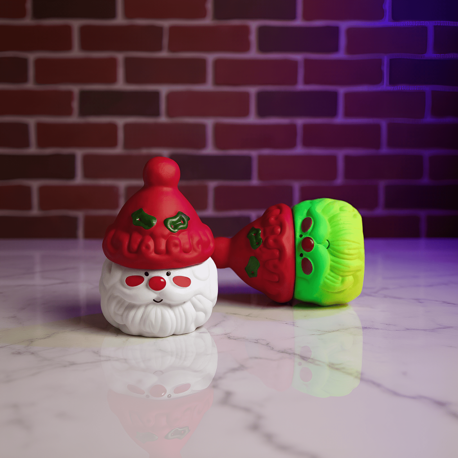 Herb Grinder – Holiday Edition grinders with a red hat and green and red body on a marble surface