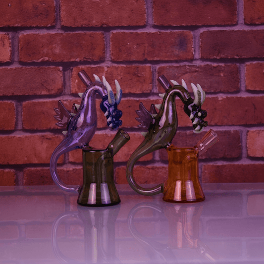 House of Dragon Glass Bong – RPG & Anime Style Water PipeTwo dragon glass with dragon designs against a brick wall background