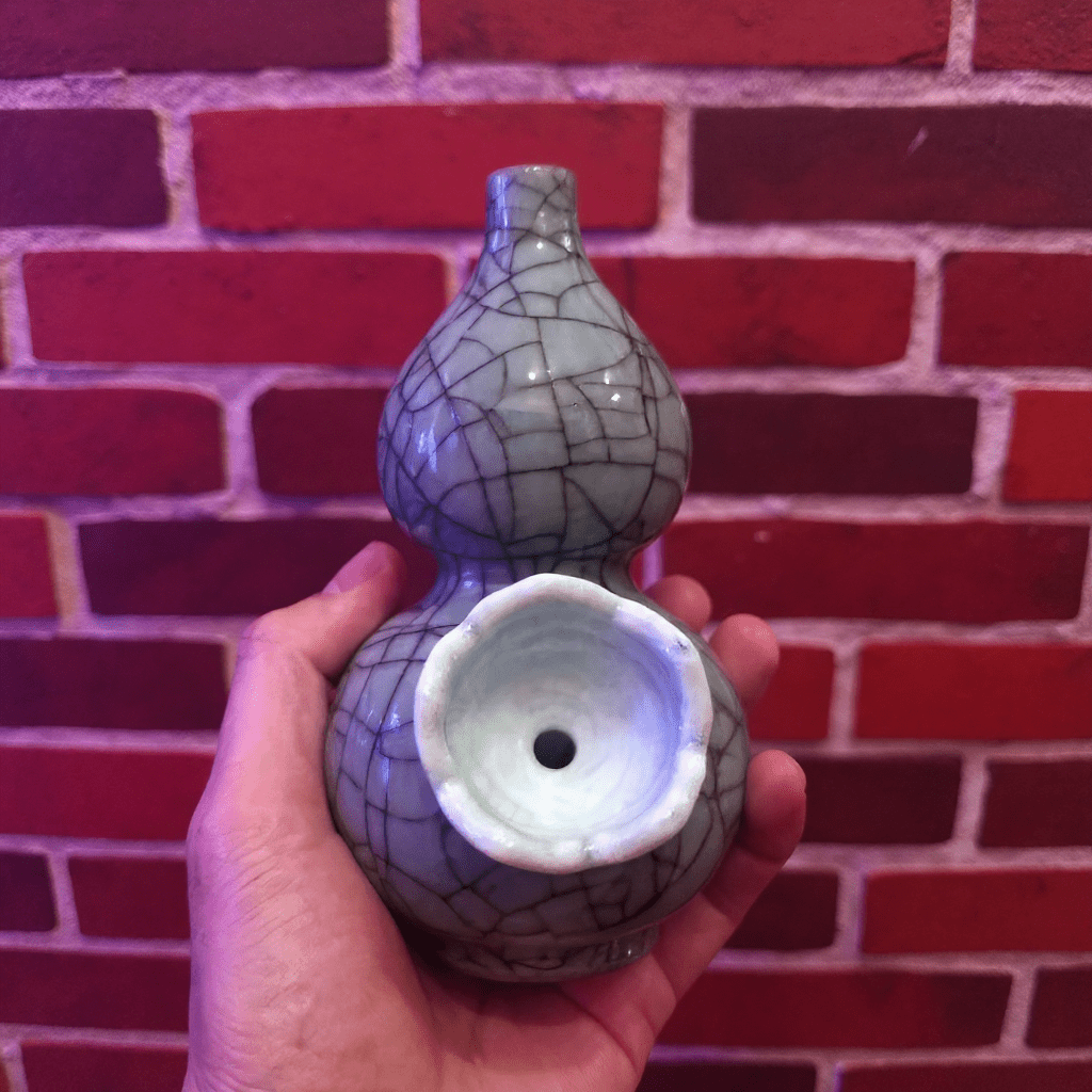 Ice - Crack Blue Celadon Gourd Porcelain BongCeramic smoking bong with cracked glaze design held against a brick wall.