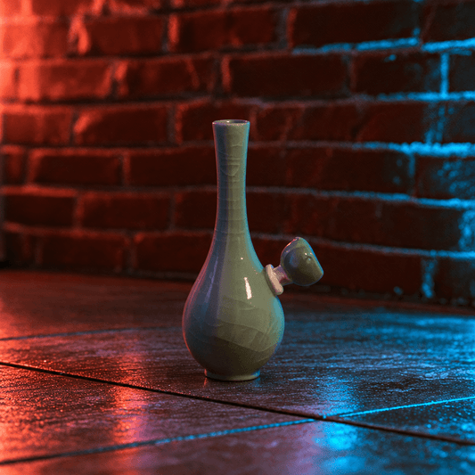 Ice-Crack Celadon Vase Bong with Slim Neck DesignA small ceramic vase with a narrow neck and a side arm, shown on a dark tabletop against a red brick wall. The vase has a glossy pale green glaze with subtle geometric texture, and the scene is lit with dramatic red and blue lighting.