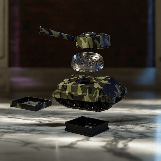 M1 Abrams Tank Grinder & Pipe Combo – Camo Battle Edition (2-in-1)A disassembled camouflage-patterned metal tank-shaped grinder with black trays, shown floating against a blurred indoor background.