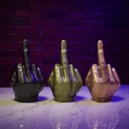 Middle Finger Grinder & Pipe Combo – Heavy Duty 2 - in - 1 SystemThree metallic middle finger grinder in black, green, and bronze on a reflective surface with a brick wall background.