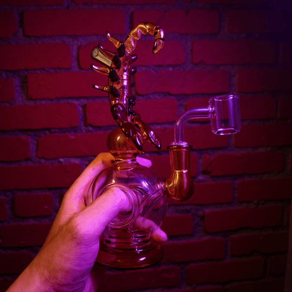 Mythical Creature Glass Bong – Fantasy StyleScorpio glass smoking bong held by a hand against a brick wall background