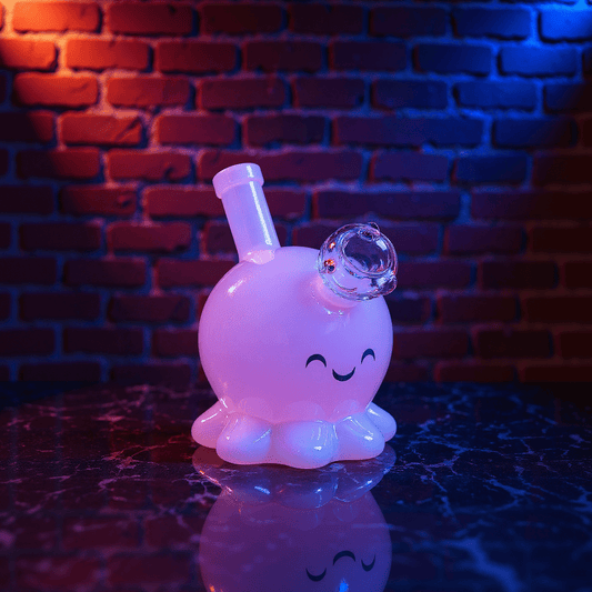 🐙 Octopus Bong - mini octopus glass bong for girlGlowing octopus glass bong with a smiley face design on a reflective surface