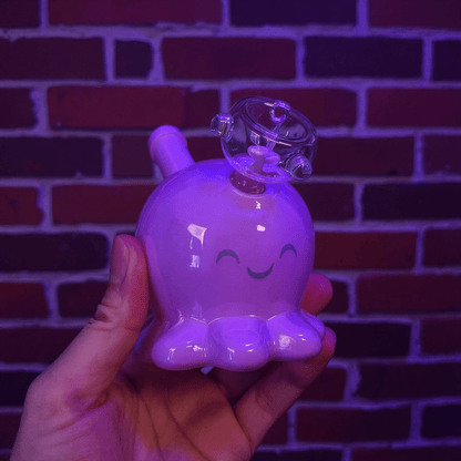 🐙 Octopus Bong - mini octopus glass bong for girlHand holding a purple octopus bong against a brick wall background