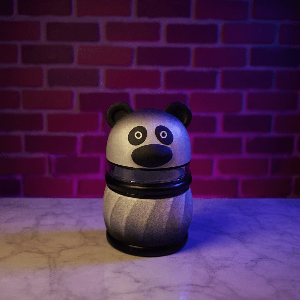 Panda Pop Herb Grinder – Cute, High Quality 4 - Piece CrusherPanda Pop Grinder – 4 - Layer Herb & Spice CrusherPanda herb grinder with black detail ring, sitting on wooden