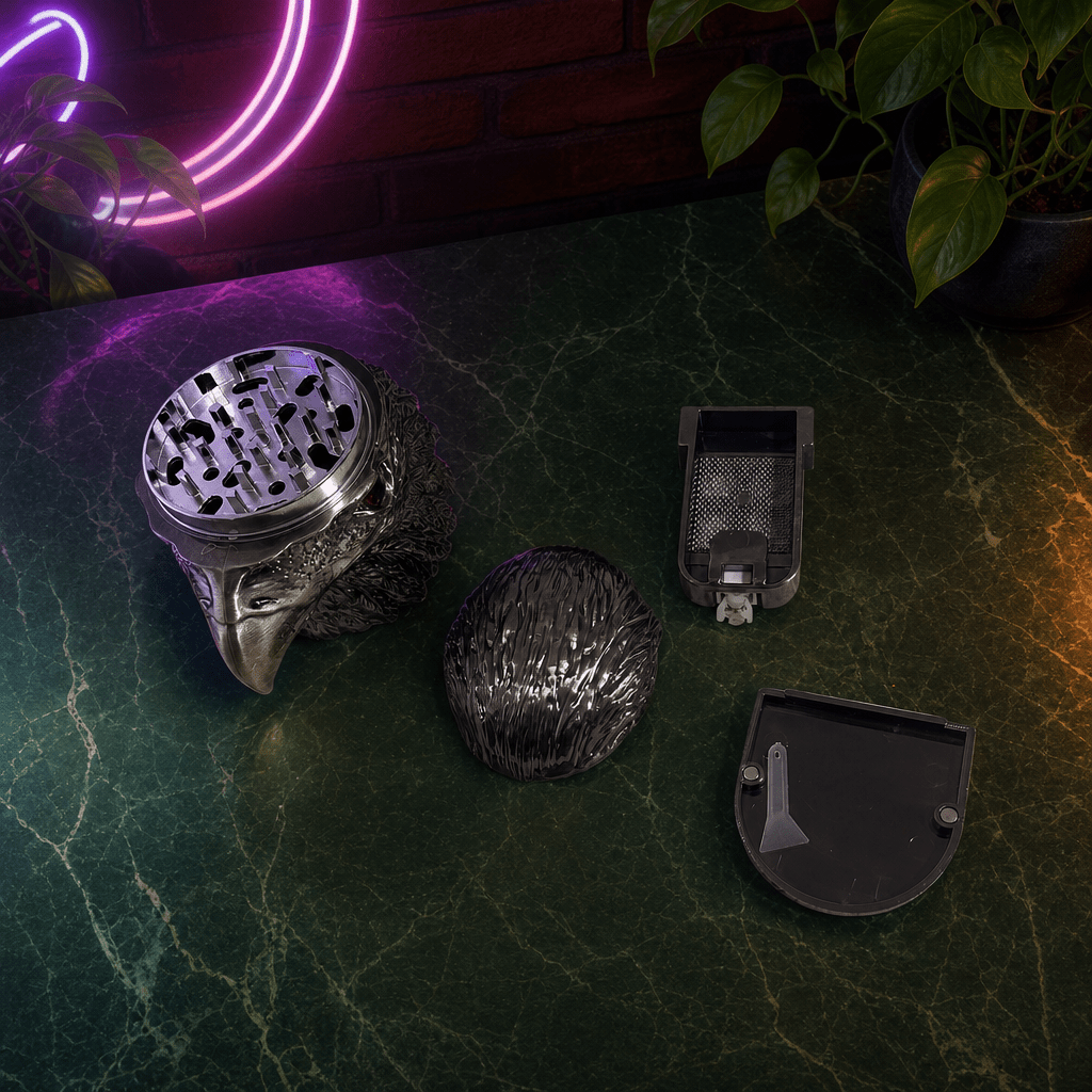 Patriot Eagle Head Metal Grinder – Brass, Bronze & Black FinishSet of metallic grinders on a dark surface with a neon light in the background