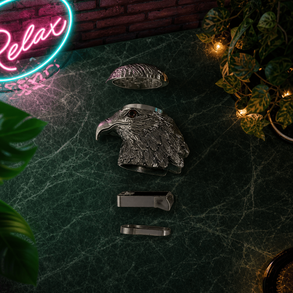 Patriot Eagle Head Metal Grinder – Brass, Bronze & Black FinishMetallic eagle head herb grinder on a dark surface with a neon 'Relax' sign in the background.