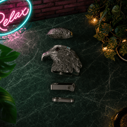 Patriot Eagle Head Metal Grinder – Brass, Bronze & Black FinishMetallic eagle head herb grinder on a dark surface with a neon 'Relax' sign in the background.
