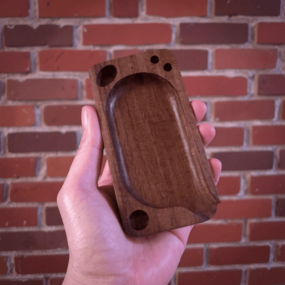 Premium Wooden Rolling Tray - Preset Tool for SmokingHand holding a wooden rolling tray against a brick wall background