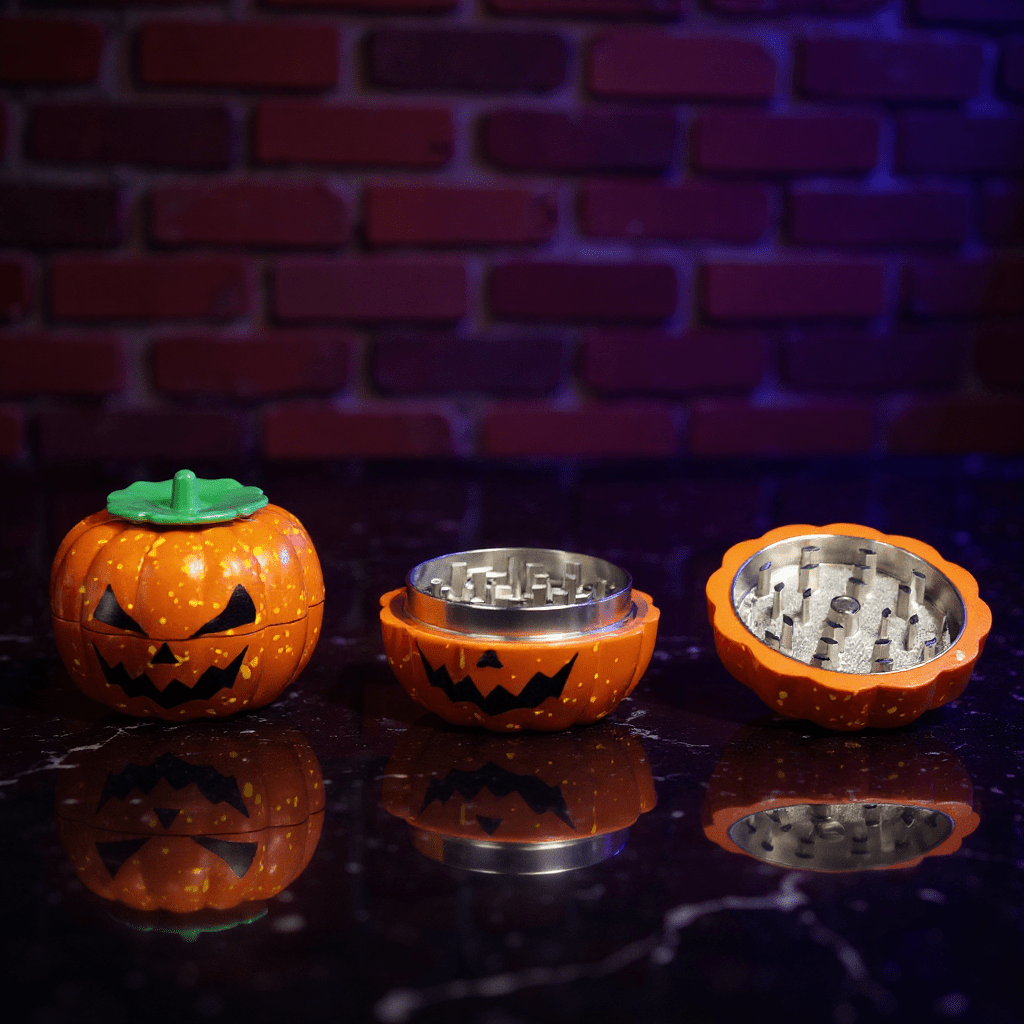 Pumpkin Herb Grinder – 3 - Piece GrinderHalloween - themed grinder with jack - o' - lantern design on a reflective surface