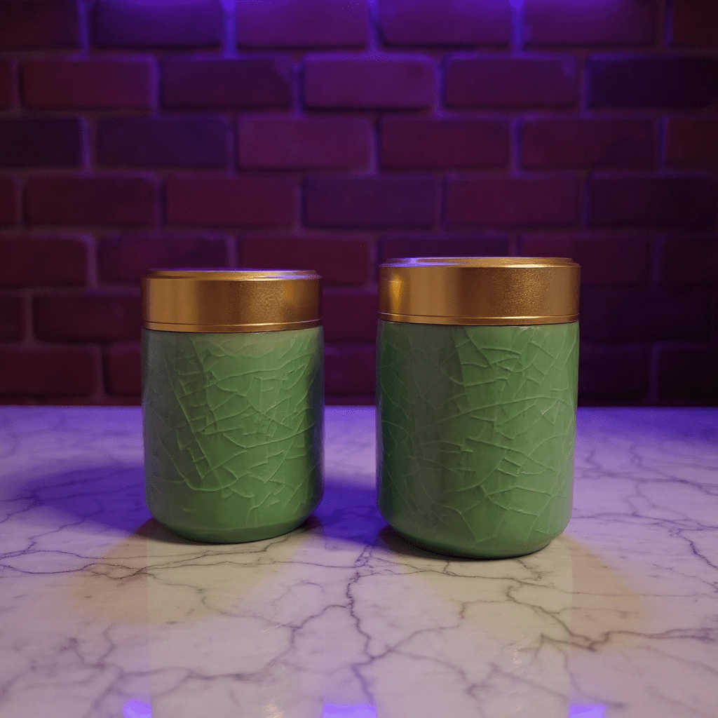 Smooth Green Celadon Porcelain Stash JarTwo green celadon porcelain stash jars with gold lids on a marble surface
