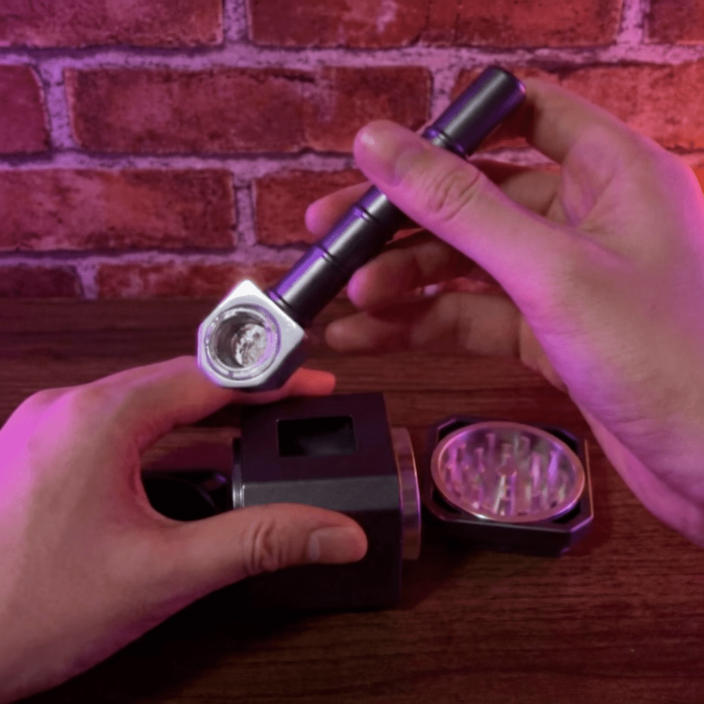 Thor Hammer Shape Grinder – 4 - Part Metal GrinderHand holding a thor hammer pipe against a brick wall backgroung