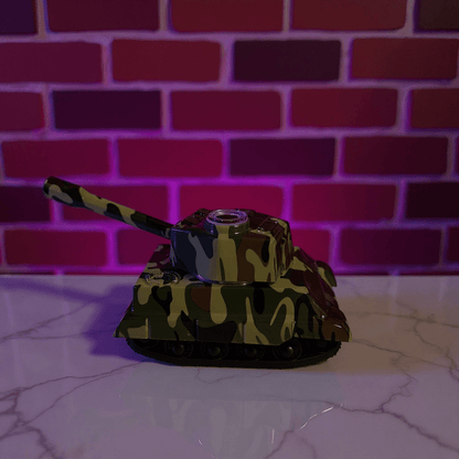 Toy tank grinder with camouflage design on a reflective surface against a brick wall background